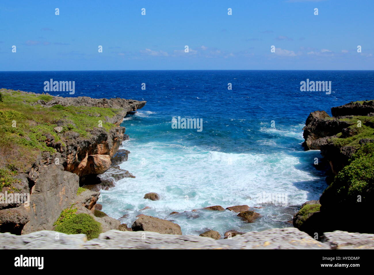 Blue waters, Saipan Water flows in a gap between the cliffs in Saipan facing the Pacific Ocean. Stock Photo