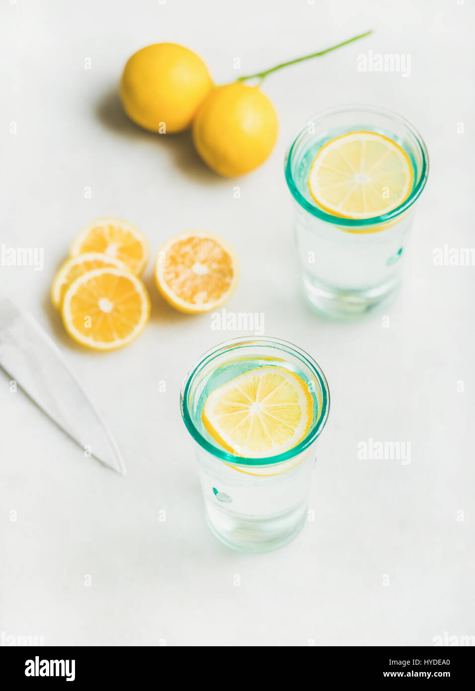 Detox lemon water in glasses served with fresh lemon fruits Stock Photo