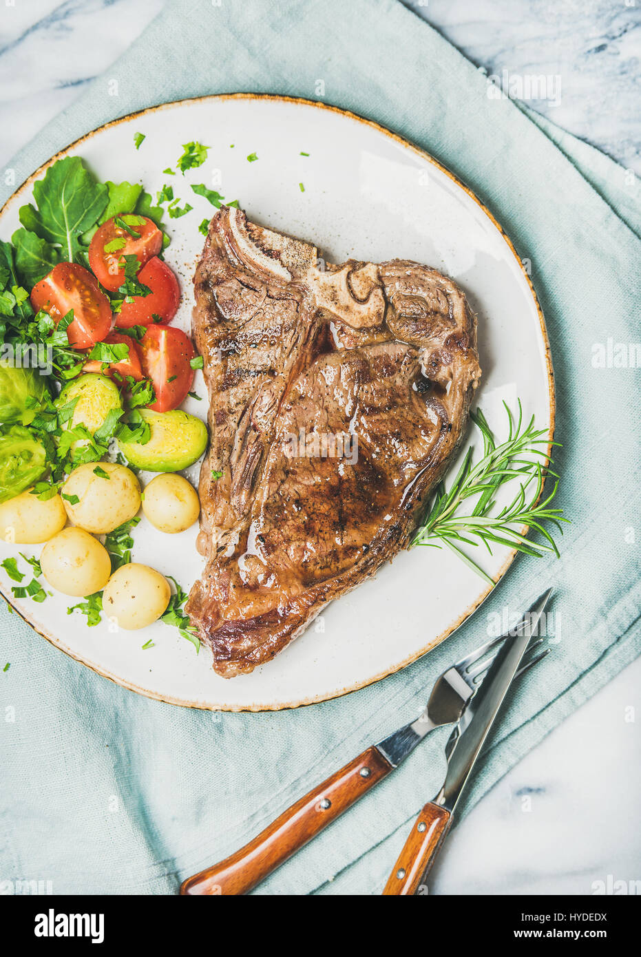 Meat dinner plate with cooked beef tbone steak, top view Stock Photo