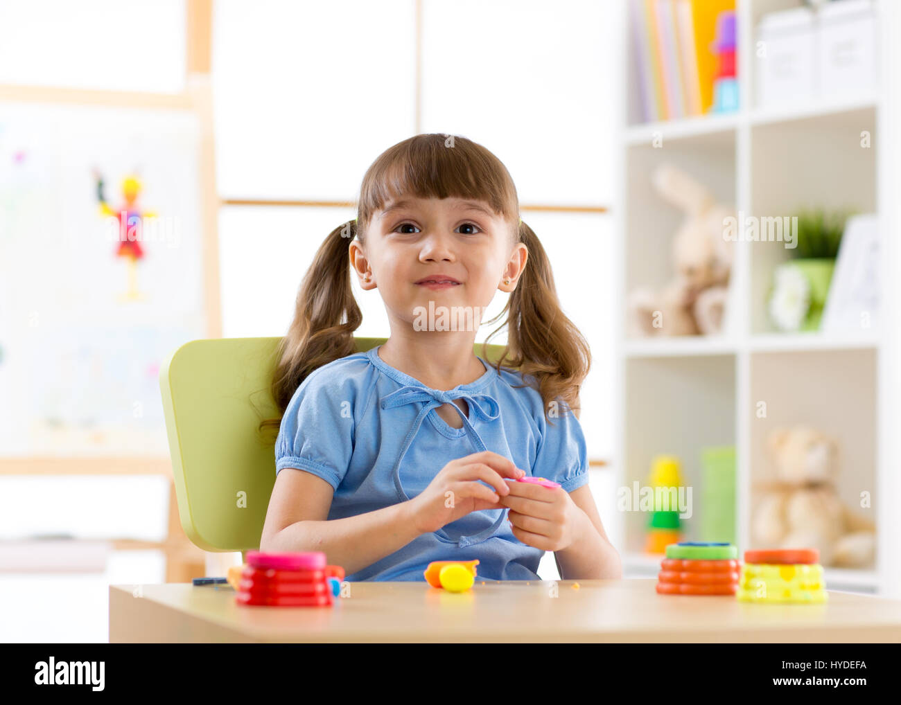 Kid girl playing with plasticine at home Stock Photo