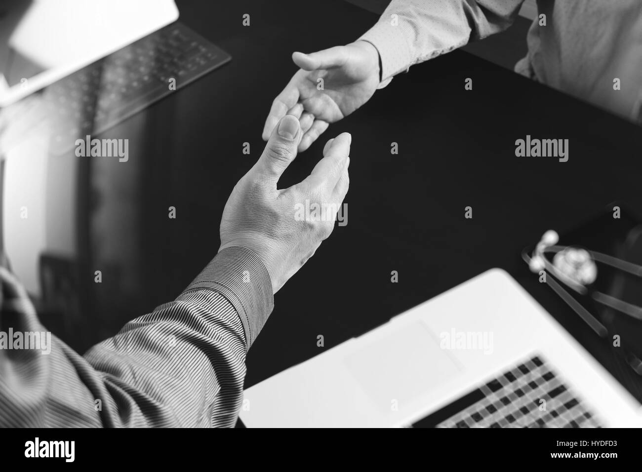Medical and healthcare concept,Doctor and patient shaking hands in modern office at hospital,black and white Stock Photo