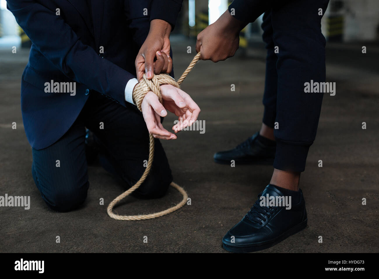 Dangerous male criminal binding the hands of a victim Stock Photo Alamy