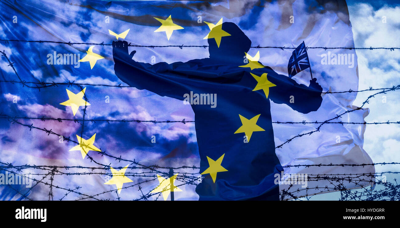 Brexit, immigration, asylum seekers... concept image. Rear view of man looking through barbed wire fence Stock Photo