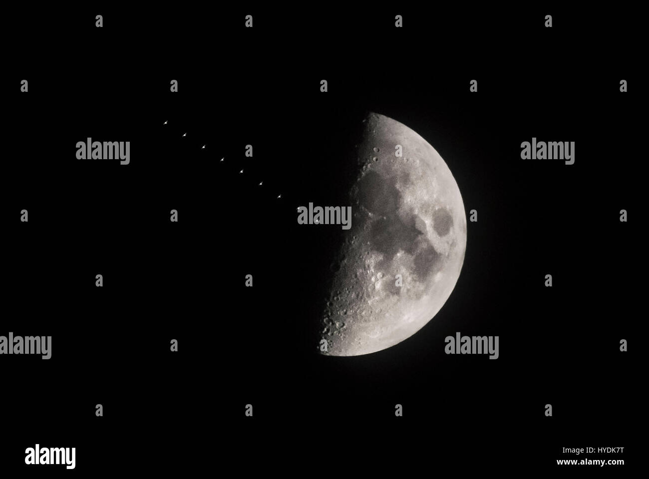Multiple exposure created in camera showing the International Space Station transiting the first quarter moon above Leeds. Stock Photo