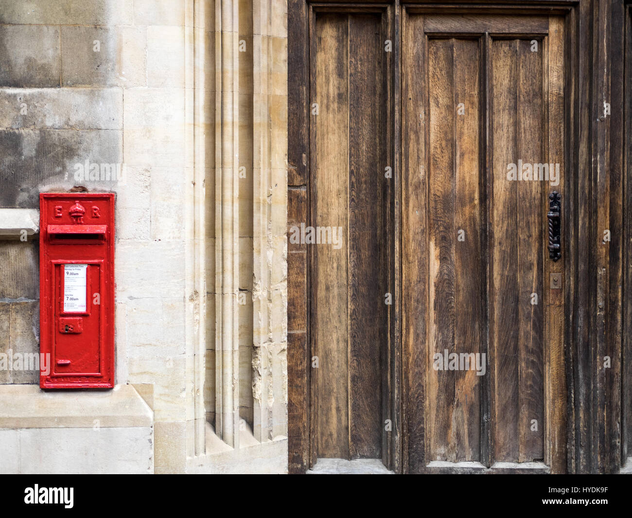 A vintage Royal Mail postbox next to a college gateway in Cambridge, UK. Stock Photo