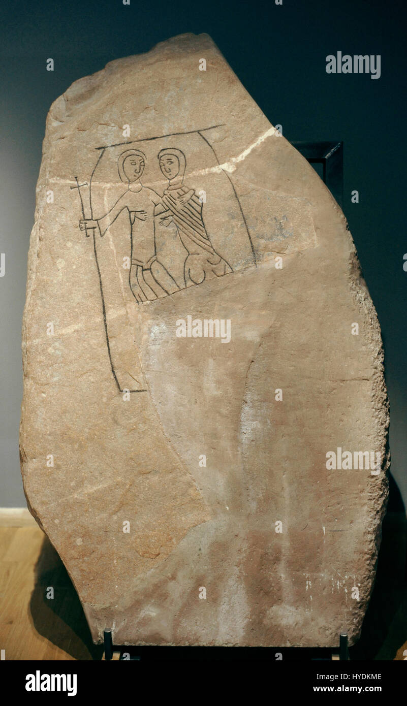 Runestone erected by Nikulaus in memory of his father Sysha. It probably represents the entrance of the father into the Kingdom of Heaven. One of them carries a cross in his hands and appears to enter a portal that could be the gates of heaven. Swedish History Museum. Stockholm. Sweden. Stock Photo