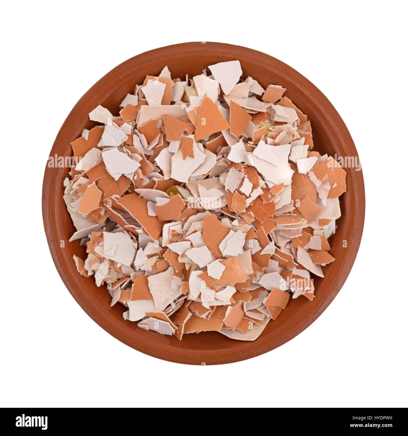Top view of a small bowl filled with crushed egg shells isolated on a white background. Stock Photo
