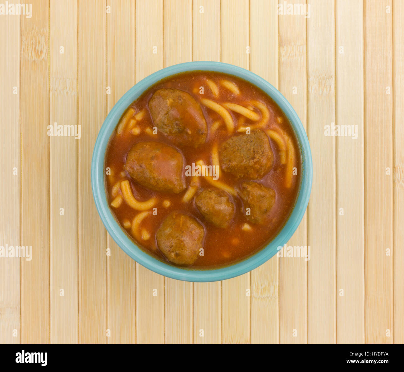Top view of a serving of spaghetti and meatballs in a bowl on a wood place mat. Stock Photo