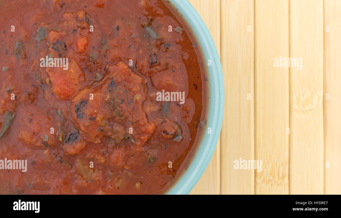 Top close view of a bowl filled with fire roasted crushed tomatoes on a