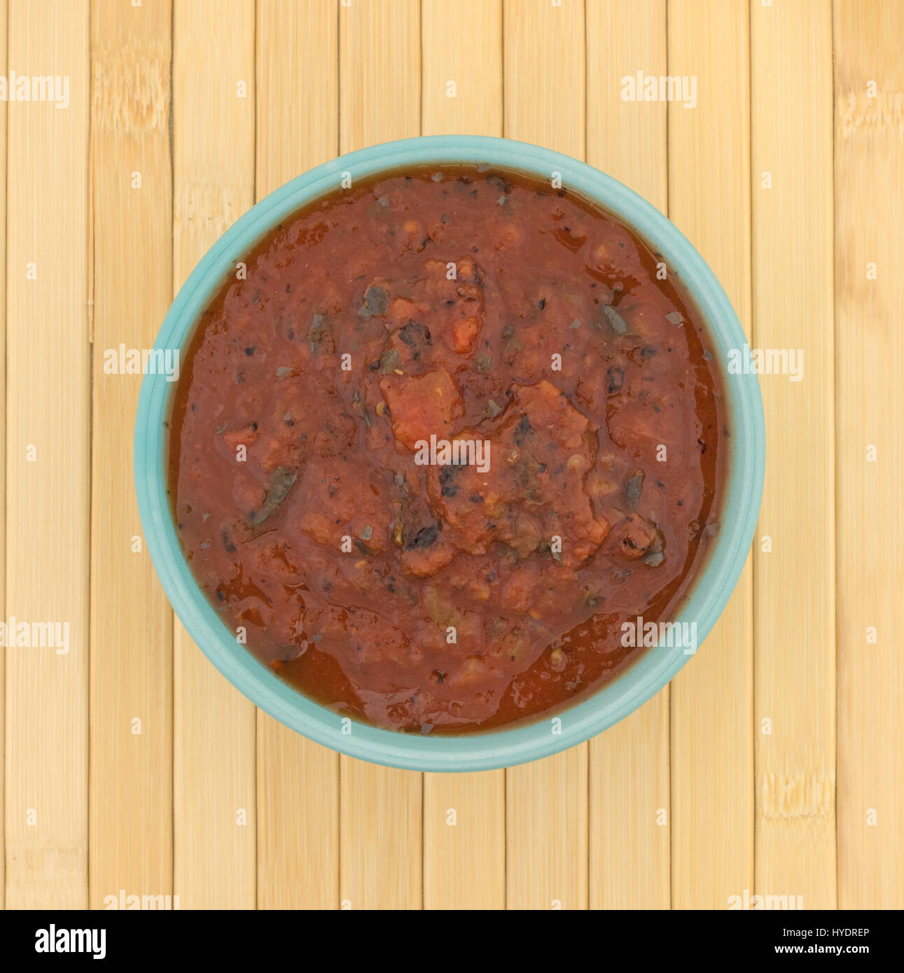 Top view of a bowl filled with fire roasted crushed tomatoes on a wood