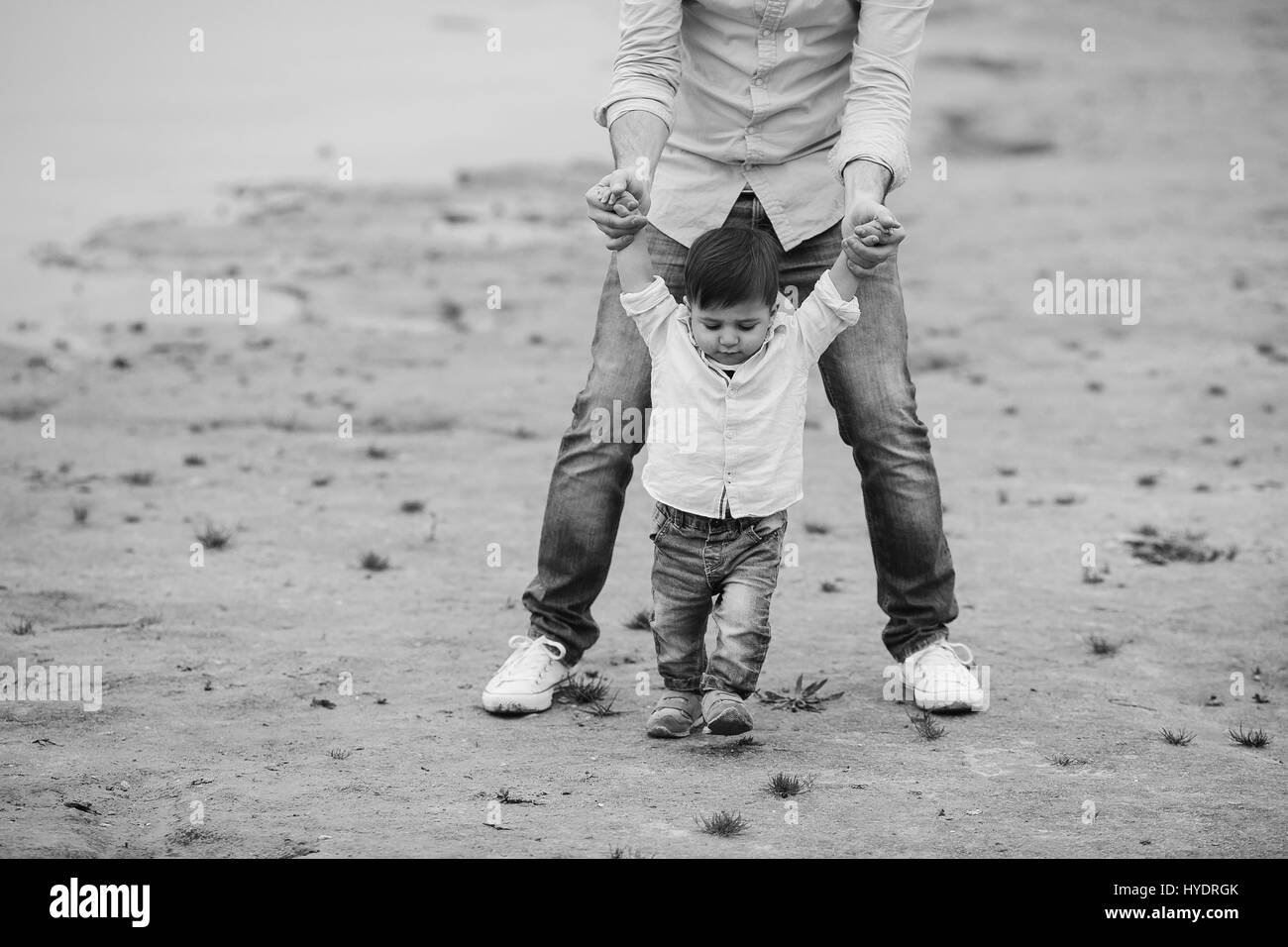 Dad holding infant son's hands Stock Photo - Alamy