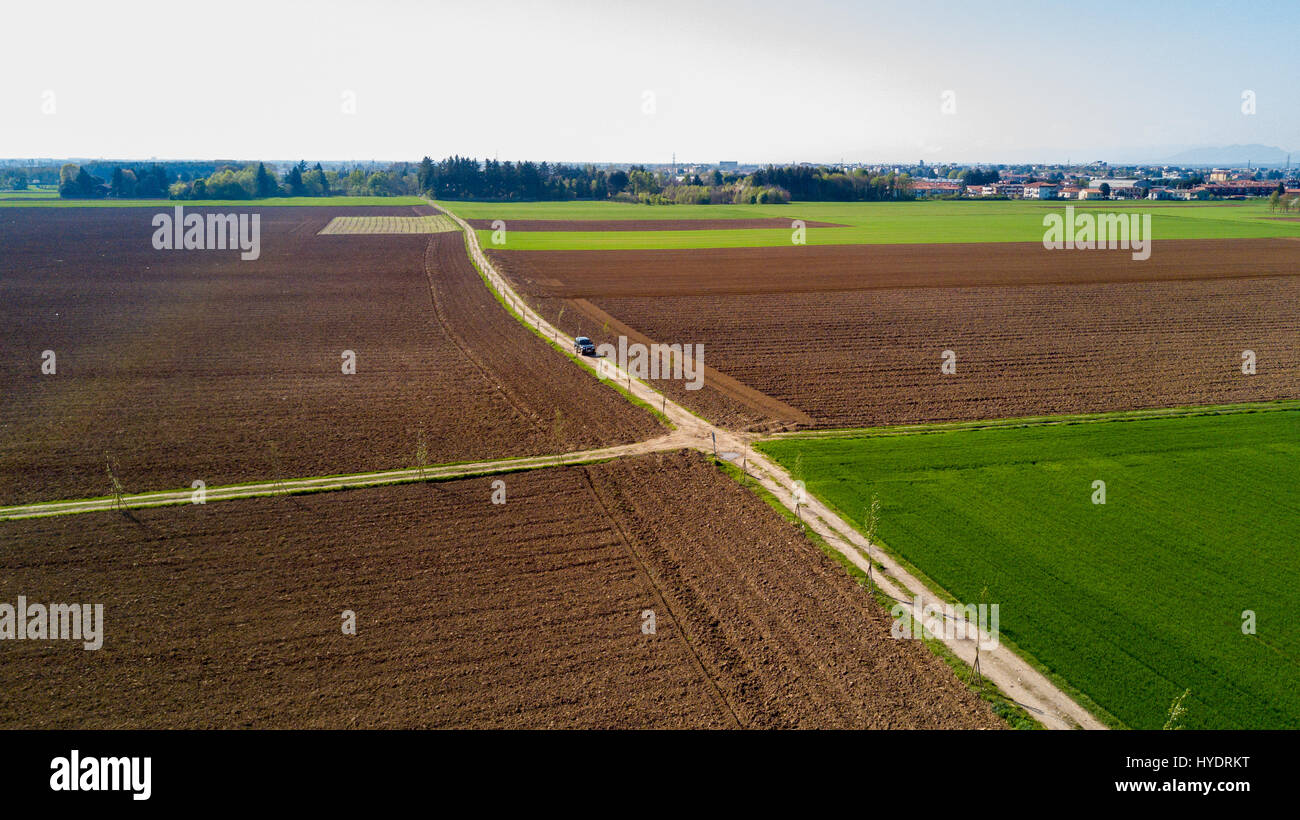 A jeep crossing a country road, off-road aerial view of a car traveling a dirt road through the fields. Traveling, spend holidays in nature Stock Photo