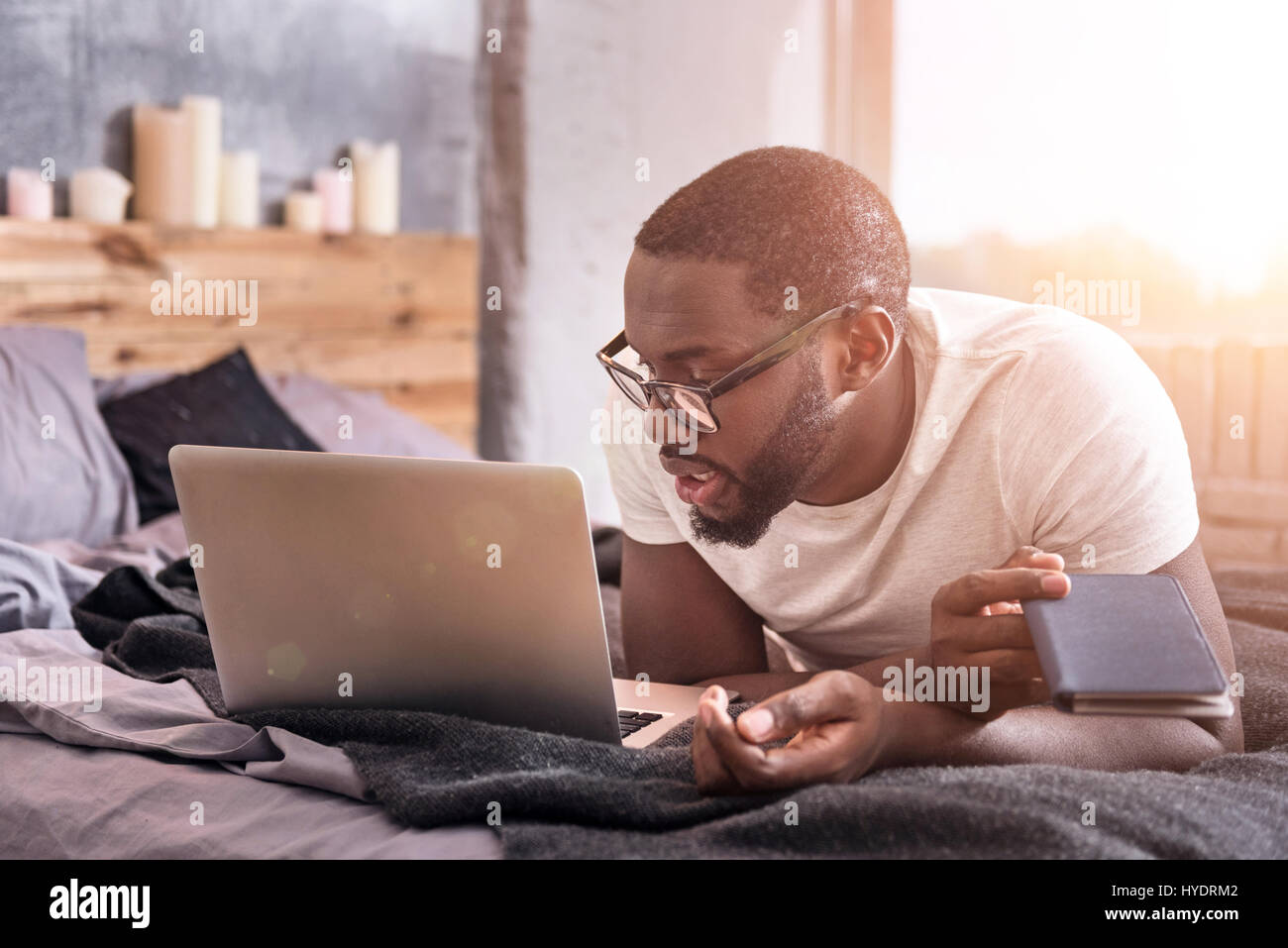 Creative young African American using gadget at home Stock Photo