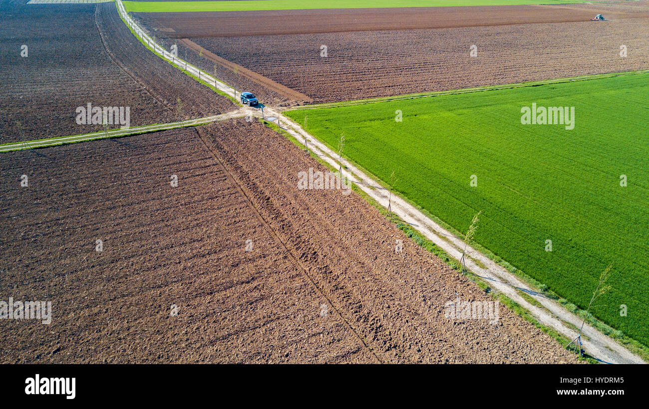 A jeep crossing a country road, off-road aerial view of a car traveling a dirt road through the fields. Traveling, spend holidays in nature Stock Photo