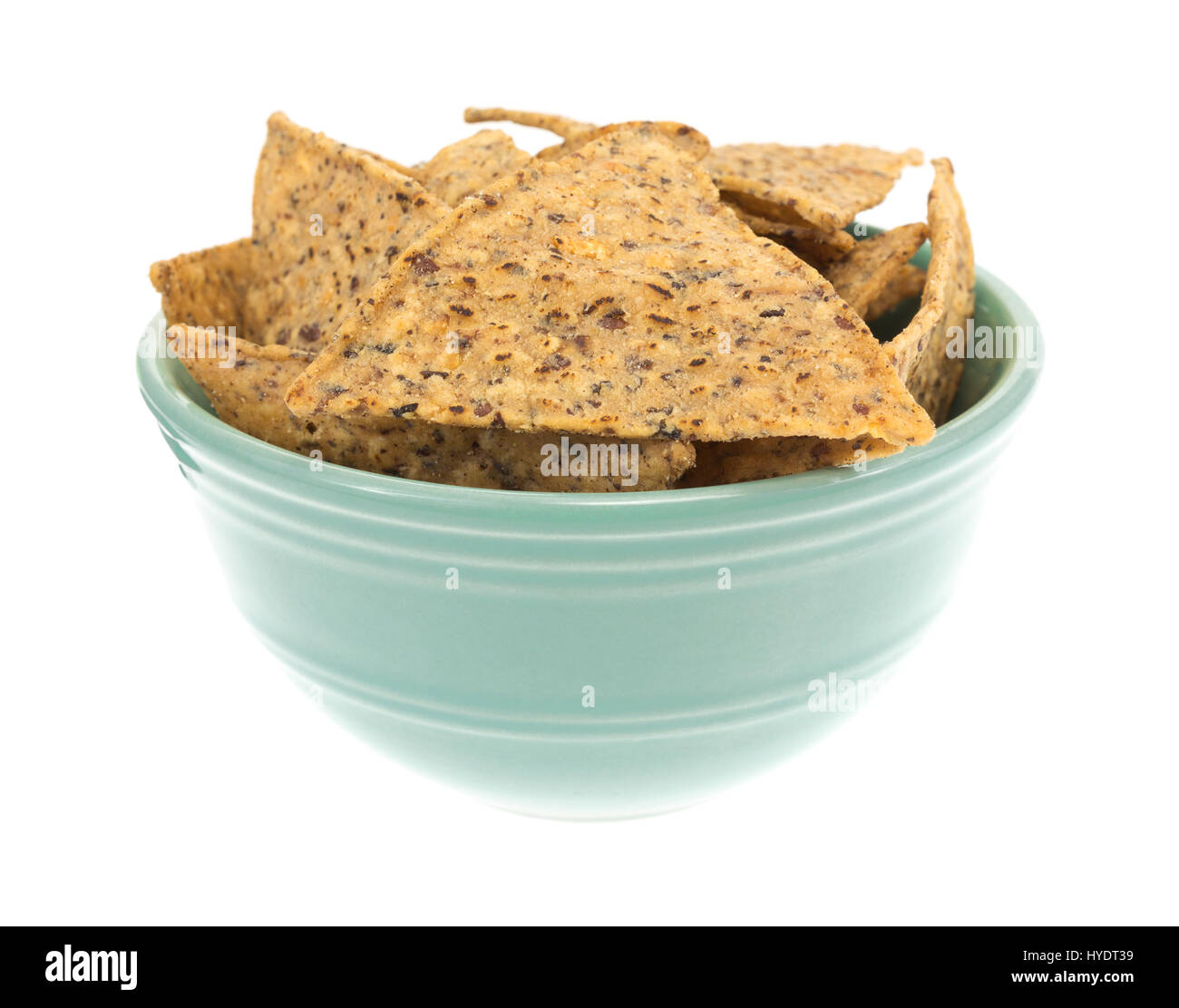 A small bowl filled with salt and pepper seasoned beans and rice chips isolated on a white background. Stock Photo