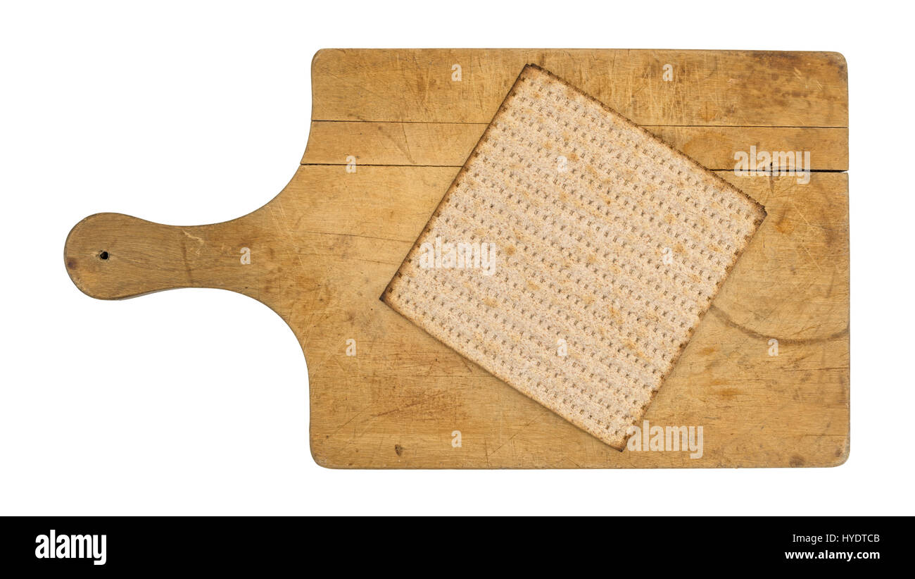 Top view of a single whole wheat matzo cracker atop an old wood cutting