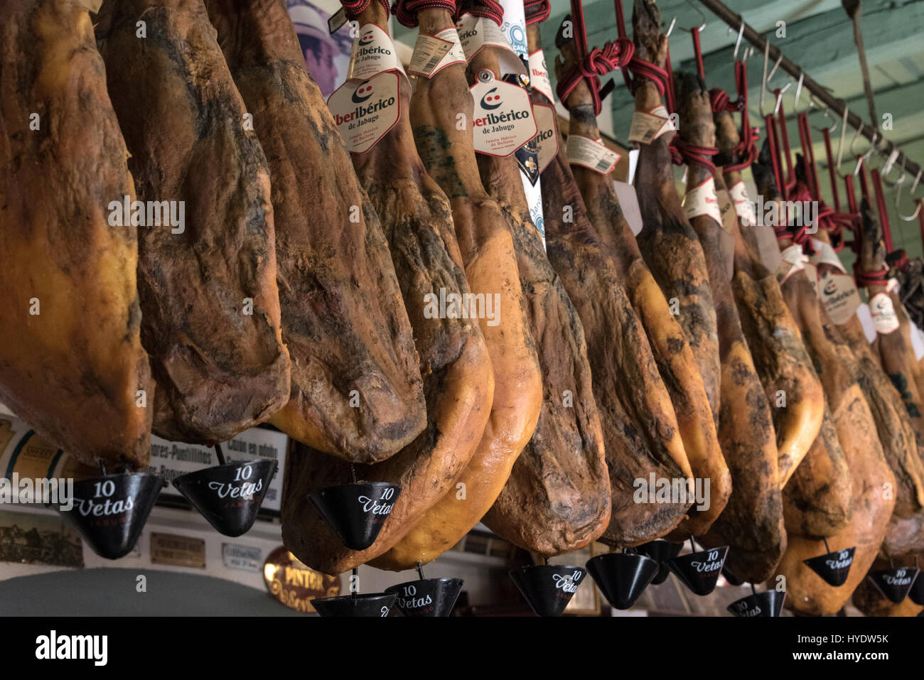 A rack of cured mountain air-dried Jamon Serrano ( Serrano ham shoulder or  dry-cured Spanish ham) hang in a row above a bar in Seville Old Town, Sevil  Stock Photo - Alamy