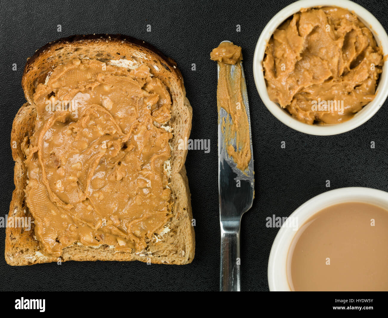 Crunchy Peanut Butter Spread on Toast Against a Black Background Stock