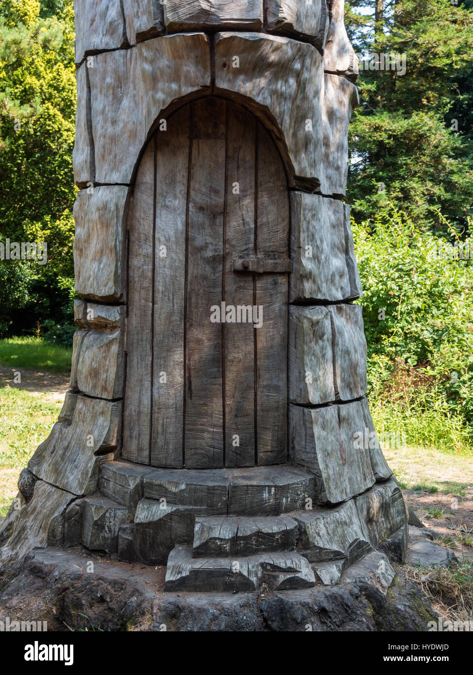 A dead tree trunk carved into a door and tower at Staughton Country Park Stock Photo