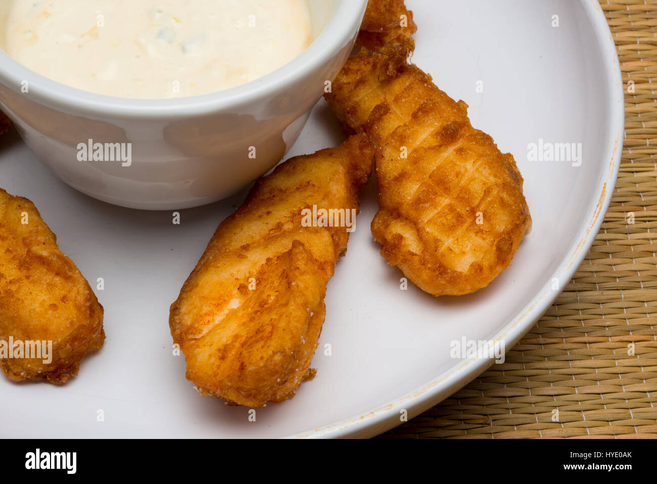 deep fried grouper fingers on white plate with dipping sauce Stock