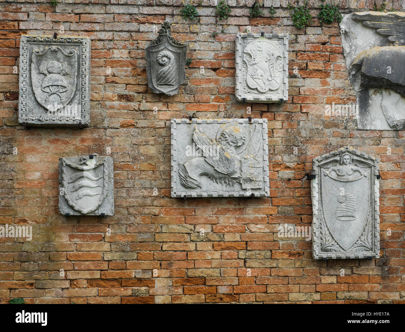 Carved wall plaques of various designs on wall on the island of Torcello, the oldest settlement in the Venetian lagoon, Venice, Italy Stock Photo