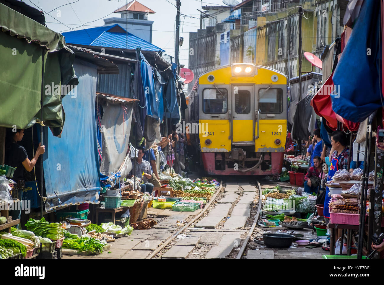 MAE KLONG - TAHILAND - CIRCA SEPTEMBER 2014: Train approaching the stalls at the Maeklong Railway Market Stock Photo