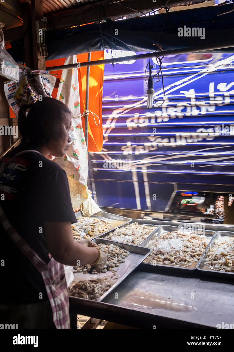 MAE KLONG - TAHILAND - CIRCA SEPTEMBER 2014: Merchant in the stalls of the Maeklong Railway Market Stock Photo