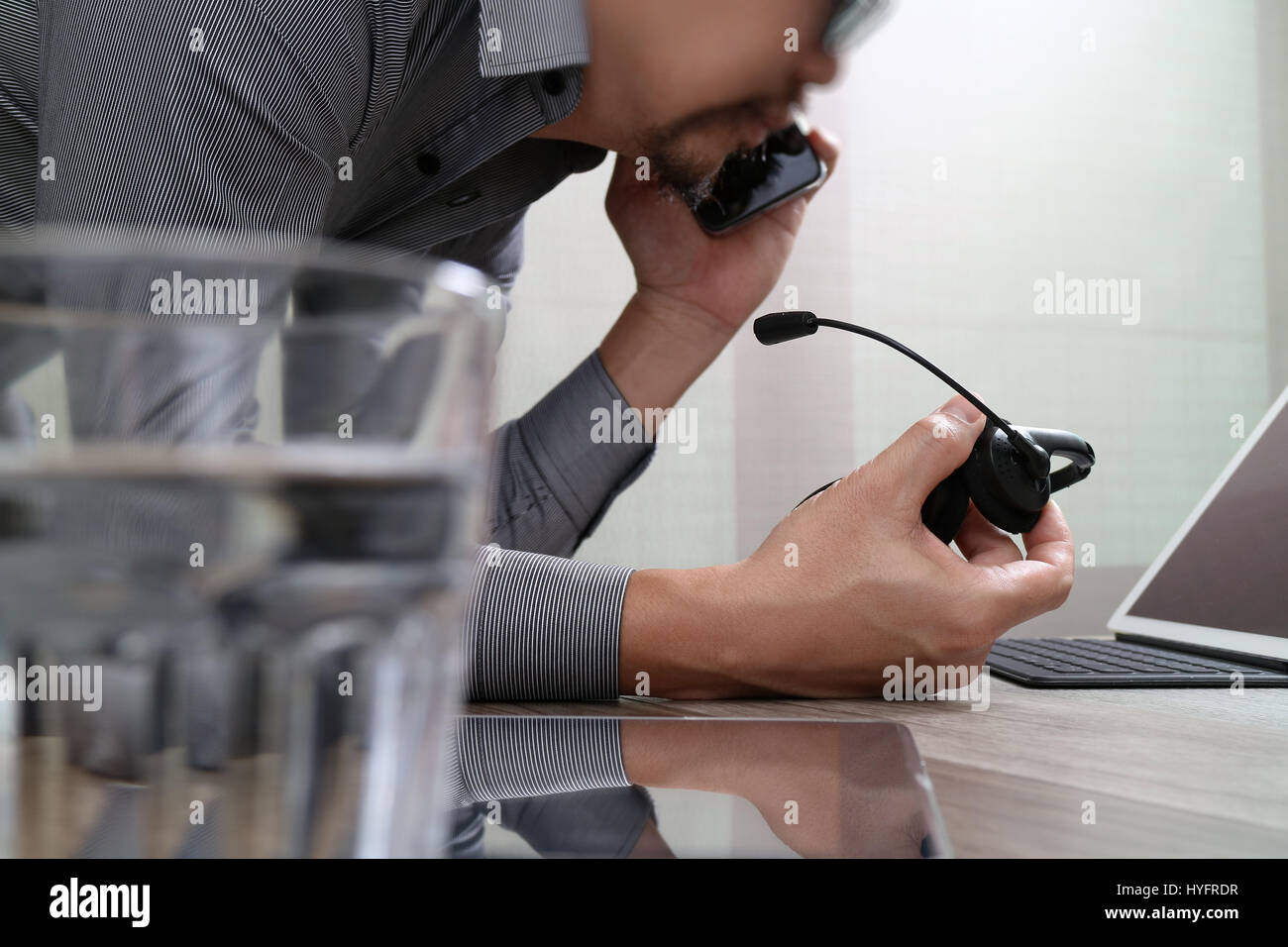 Man using VOIP headset with digital tablet computer docking smart keyboard, concept communication, it support, call center and customer service help d Stock Photo