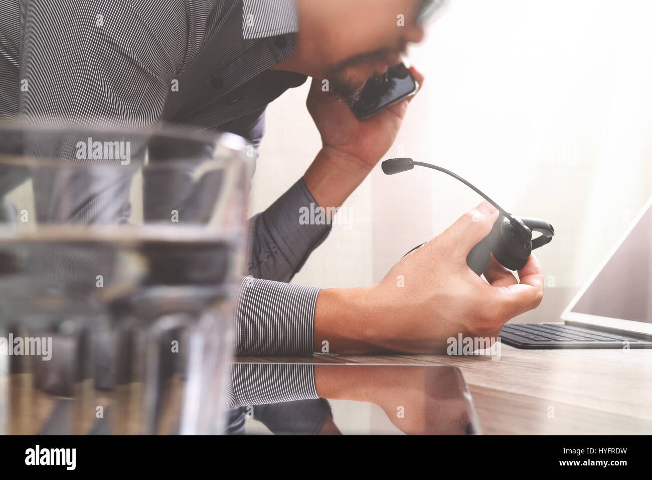 Man using VOIP headset with digital tablet computer docking smart keyboard, concept communication, it support, call center and customer service help d Stock Photo