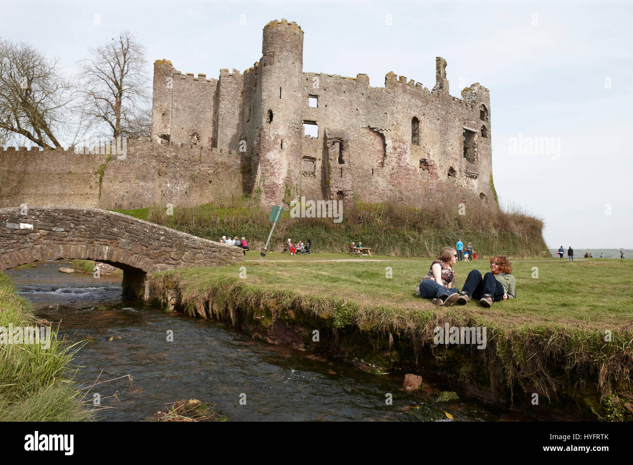 Two people relaxing by the water outside a Laugharne Castle, The Literary Festival, Laugharne, Wales, Uk Stock Photo