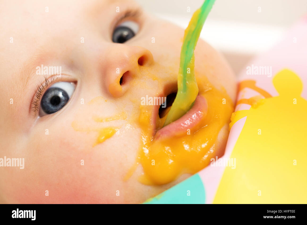 funny closeup of feeding baby with vegetable puree Stock Photo