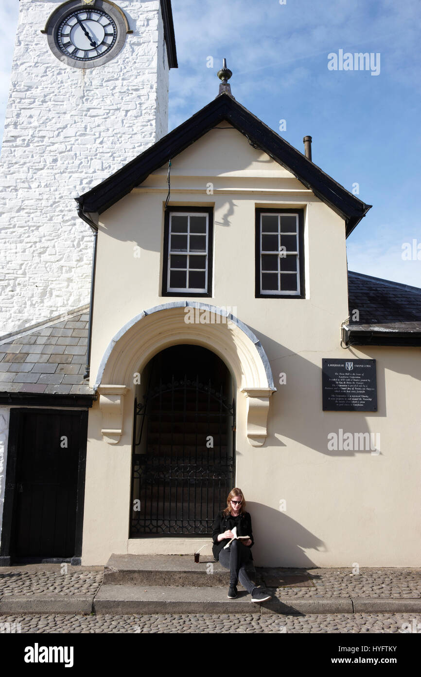 Lady Reading in the sun outside a building, Book Festival, Laugharne Stock Photo