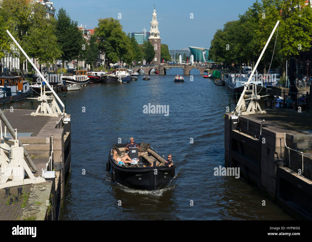 Tourist boats on canals of Amsterdam in summer sunshine, Netherlands, Europe Stock Photo