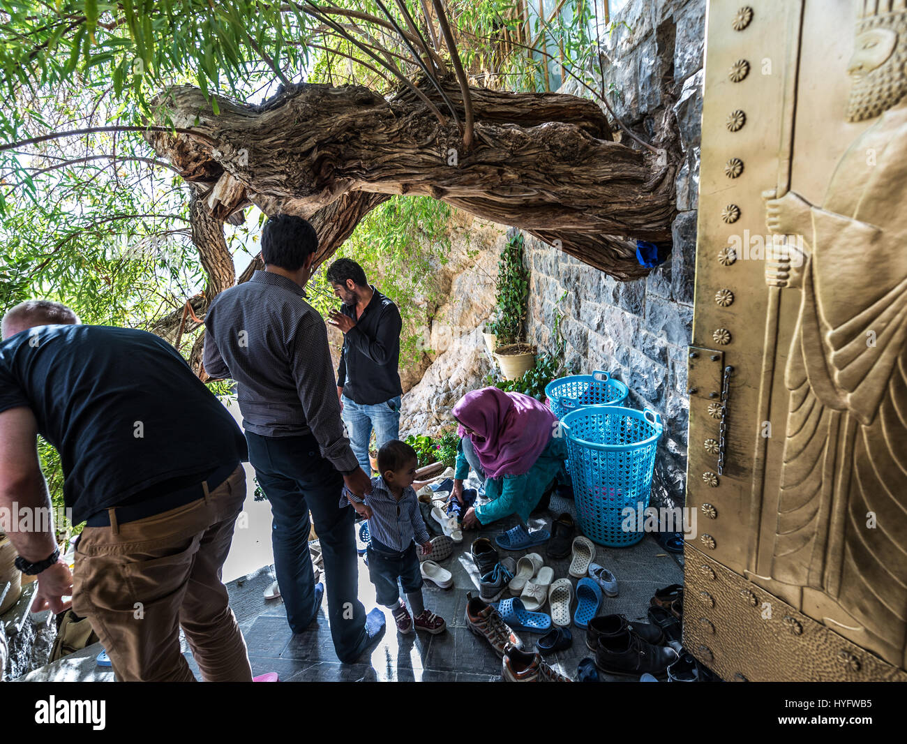 Tourists take off shoes in front of most sacred of Zoroastrian temples in Chak Chak (also spelled as Chek Chek) famous village in Iran Stock Photo