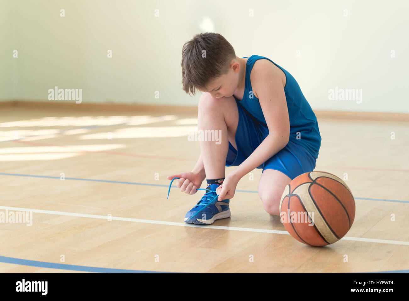 A backetball player lacing shoes Stock Photo