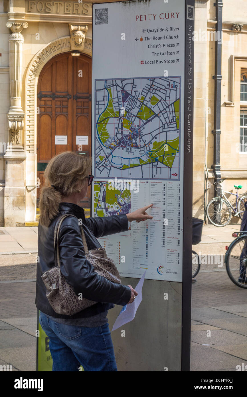 Lady tourist looking at map of Cambridge centre for places of interest Stock Photo