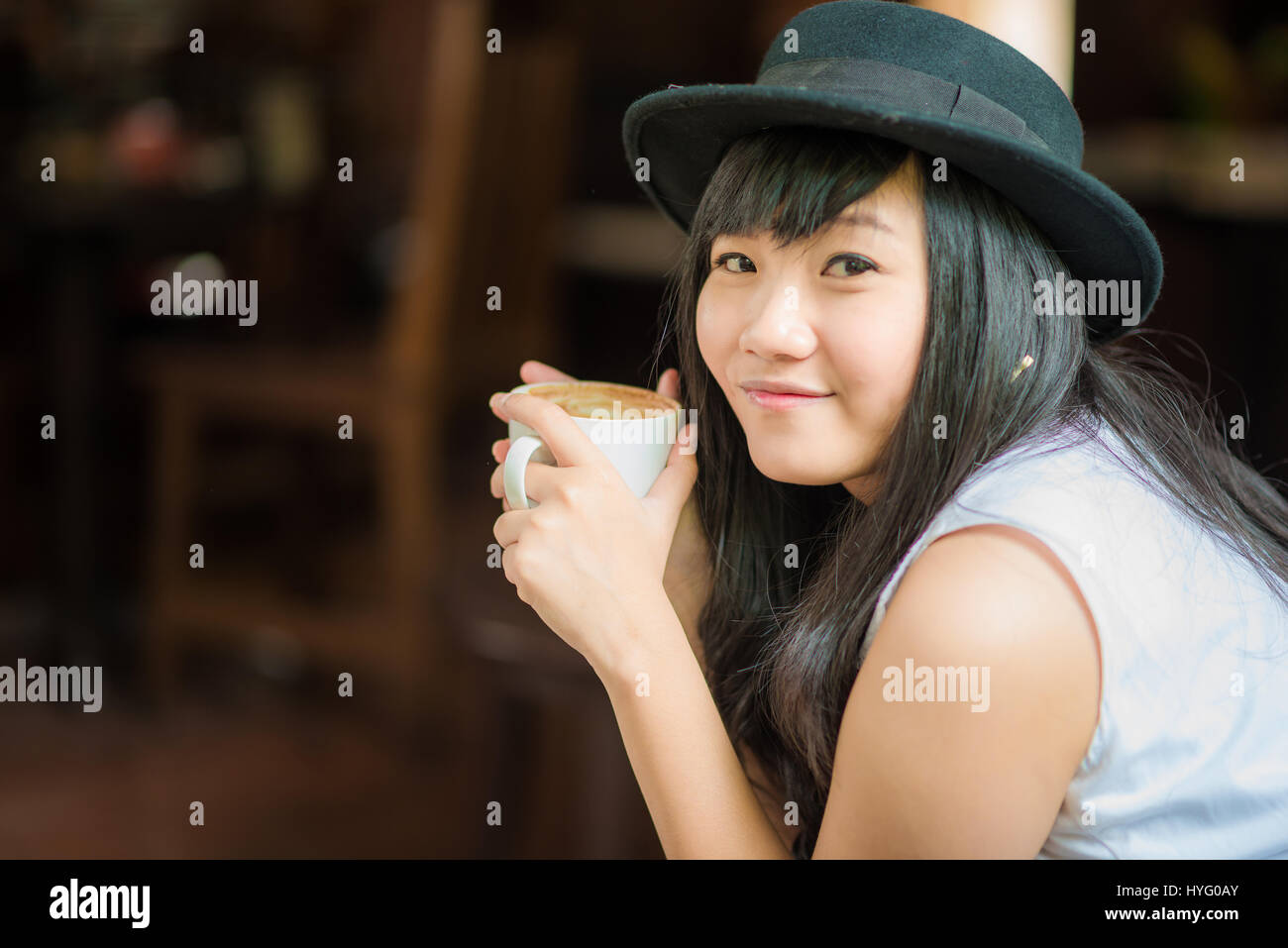 Asian young woman holding coffee cup smiling looking at camera, Close ...
