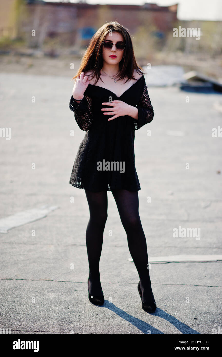 Portrait brunette girl with red lips wearing a black dress, tights and shoes on heels posed on the roof. Street fashion model Stock Photo - Alamy Portrait brunette girl with red lips wearing a black dress, tights and shoes on heels posed on the roof. Street fashion model Stock Photo - Alamy