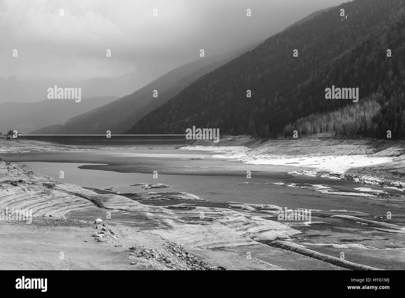 The reservoir Lago di Zoccolo in the Ulten Valley in South Tyrol. The lake is part of the waterpower production in the area. The picture is monochrome Stock Photo