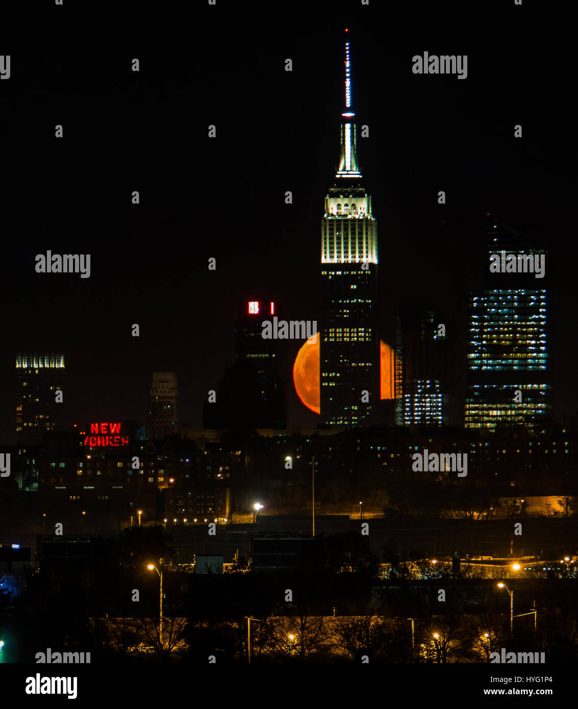 NEW YORK, USA: New York's iconic Empire State Building. CAUGHT between the moon and New York City the statue of liberty appears to have her torch lit with an orange ball of light. Incredible images show the full blood moon rising up over the iconic green lady, illuminating the city below in orange hues.  Other pictures show the Empire State building being back lit by this spectacular celestial disc. American technical writer Jennifer Khordi (46) was able to capture these awe-inspiring shots from the skyline of Jersey City and Kearny town in New Jersey. Stock Photo