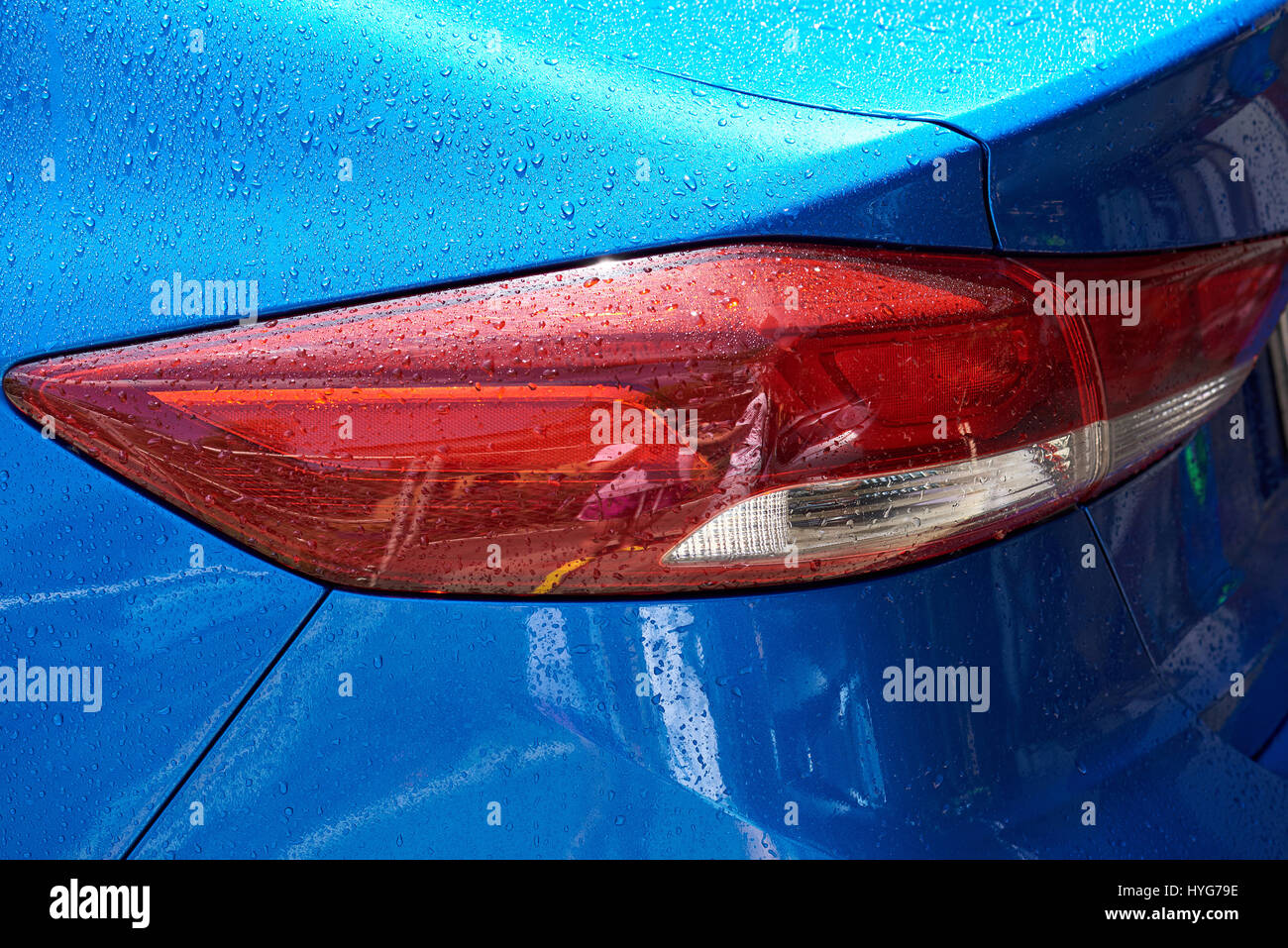 Modern blue car tail light in wet rain drop. Red modern car back light Stock Photo