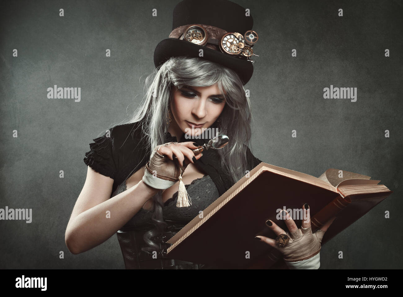 Steampunk woman with book and magnifying lens Stock Photo