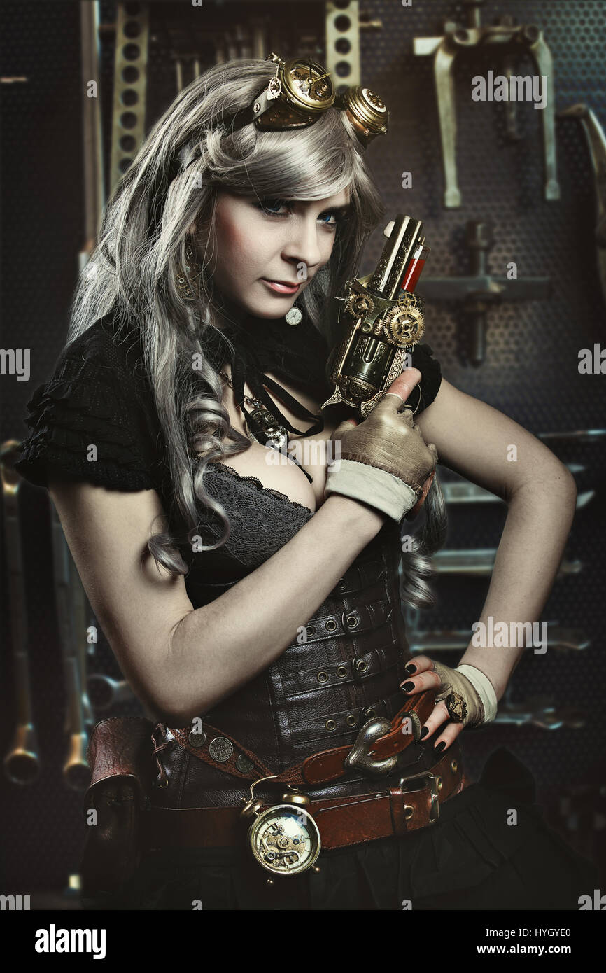 Portrait of steampunk woman with gun. Mechanical background Stock Photo