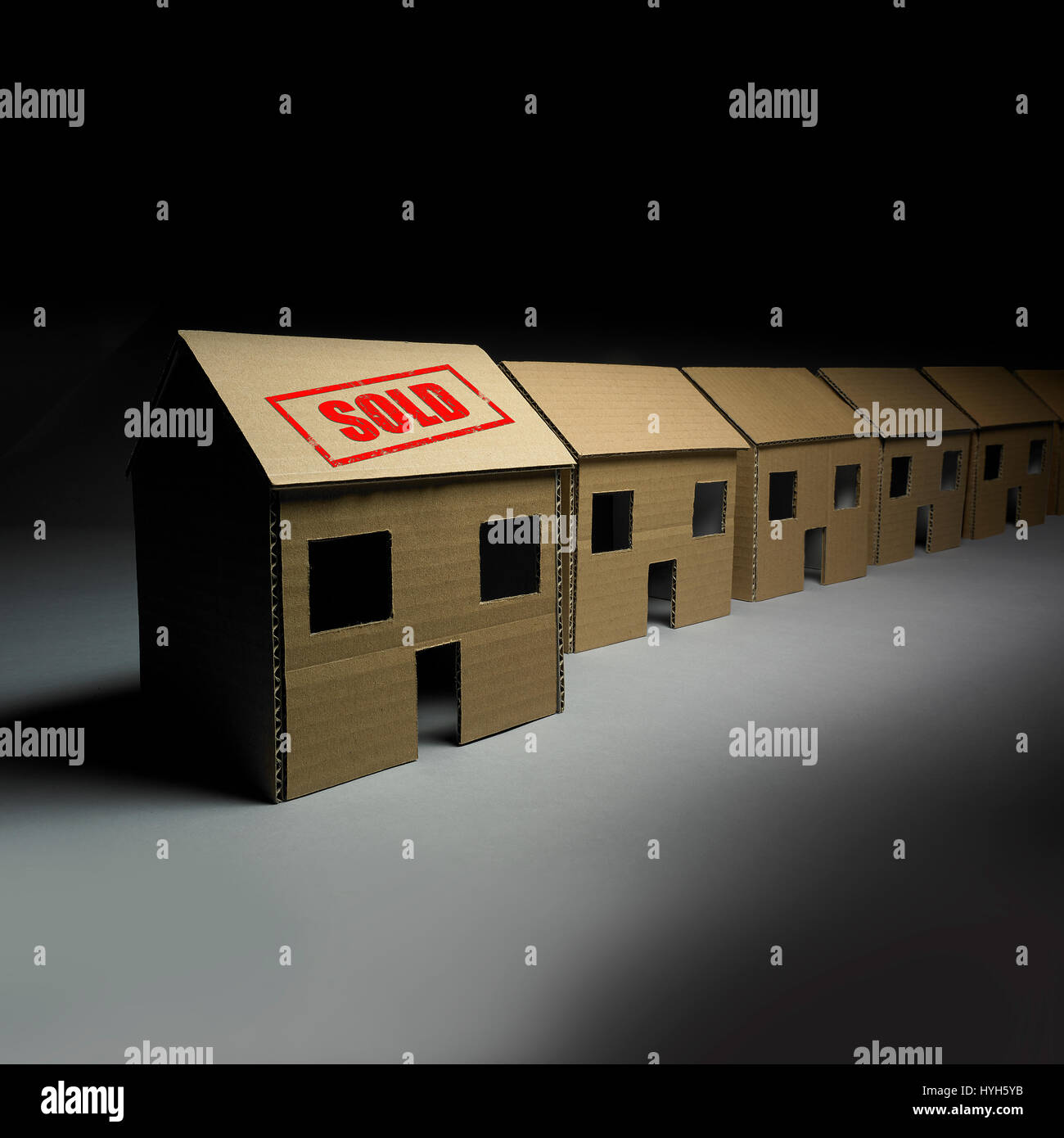Row of Cardboard Houses, one sold. Stock Photo