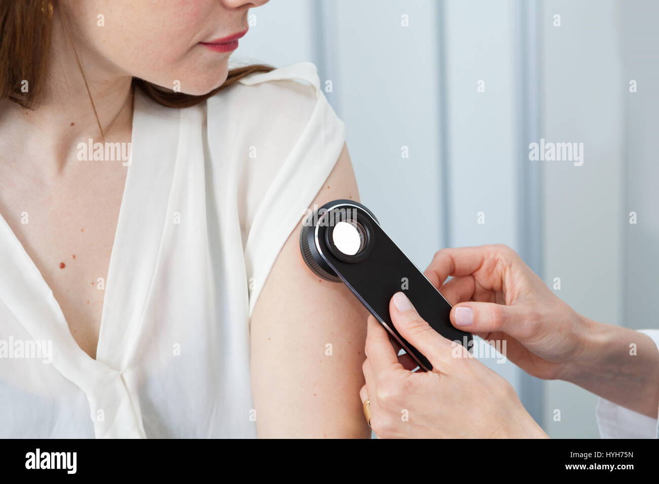 Dermatologist examining birthmarks and moles on a female patient (examination of birthmarks) Stock Photo