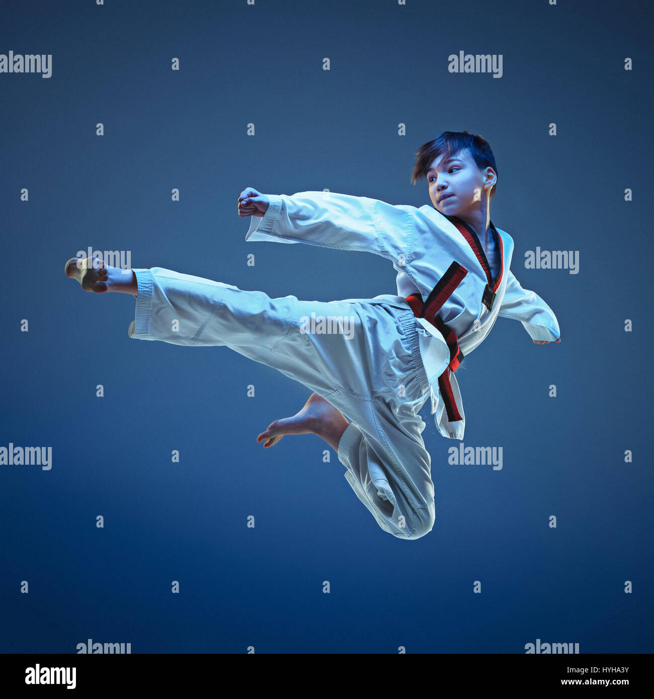 Young boy training karate on blue background Stock Photo Alamy