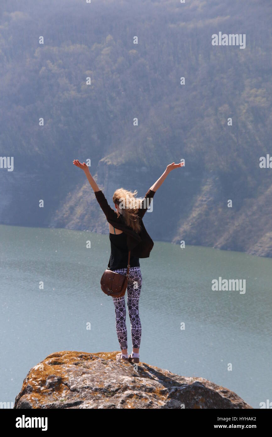 Summer, Travel or vacation idea, free cheering woman open arms at mountain peak Stock Photo