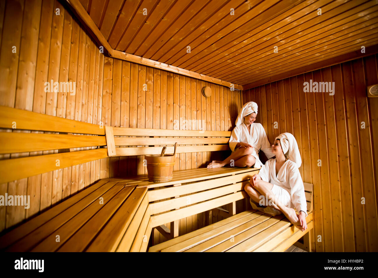Two women in wellness and  spa center relaxing in wooden sauna Stock Photo