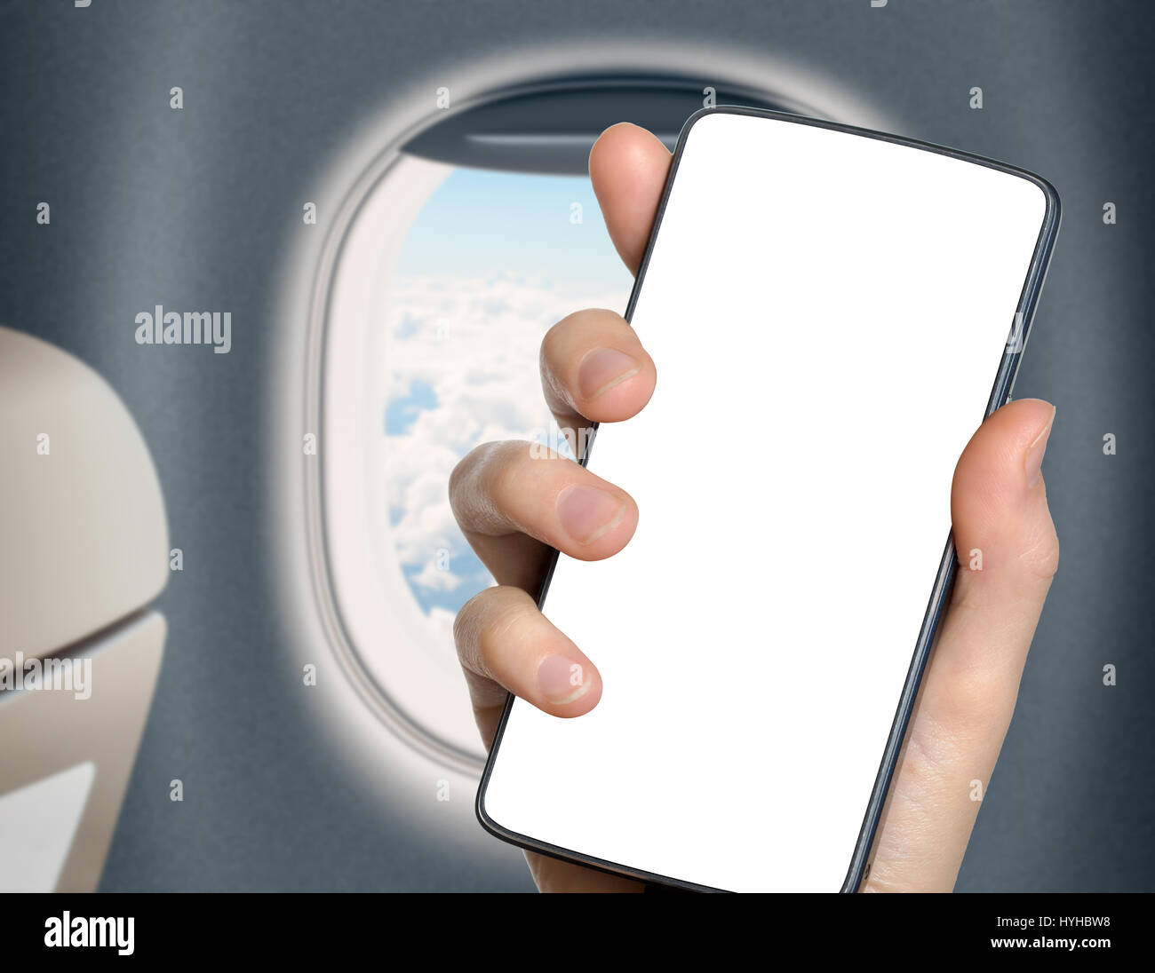 hand with blank mobile phone in airplane or jet interior Stock Photo