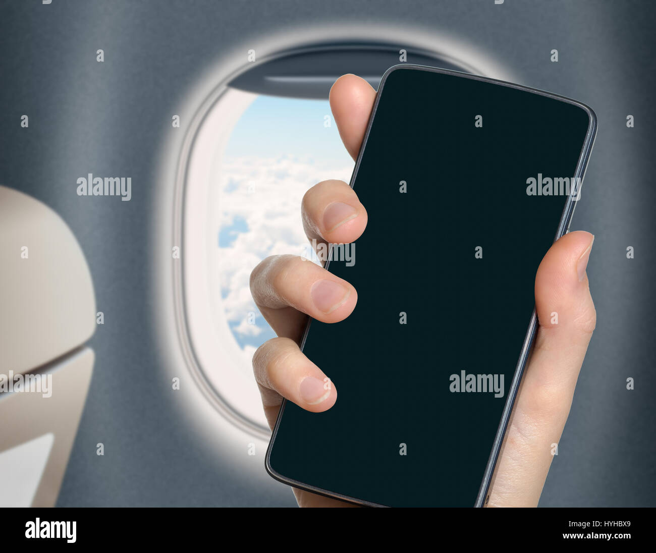 hand with blank mobile phone in airplane or jet interior Stock Photo